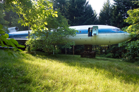 Bill Campbell opens one of 9 exits in the Boeing 727-200 that he converted into a home in rural Hillsboro, Oregon. He acquired the jet at the end of its flying life from Olympic Airways in Greece, had it flown from Athens to Oregon, and finally towed to his land.