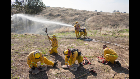 Newly hired seasonal firefighters coil and carry hoses in Friant, Calif. during their first week of training on Thursday, Feb. 13. 'I can't remember a time when we've hired seasonals in February,' said Capt. Ryan Michaels of the California Department of Forestry and Fire Protection’s Fresno-Kings Unit, 'Last year it was April - and that was early.' Anticipating a busy fire season due to drought, CalFire has hired 65 additional firefighters in the central Sierra region.