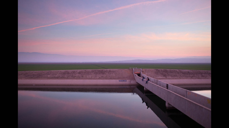 Kelly Goad and Casey Brown fish for striped bass in the California Aqueduct near Taft, Calif. on Wed. Feb 12. Beyond them are fields irrigated from the aqueduct, which conveys water from the Delta to Southern California.