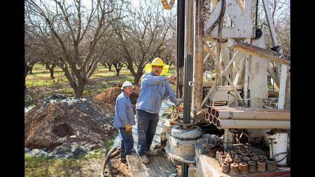 Adalberto Becerra drills a test well on Thursday, Feb. 13 in an almond orchard in Le Grand, Calif. Uncertainty about irrigation this spring has increased demand for well drilling in the Central Valley. 'We’re usually 60 days behind,' said Becerra’s boss Joe Silvira of Quality Well Drillers, 'but now we’re 100 days out.' Wells near Le Grand typically reach about 800 to 1500 feet down.