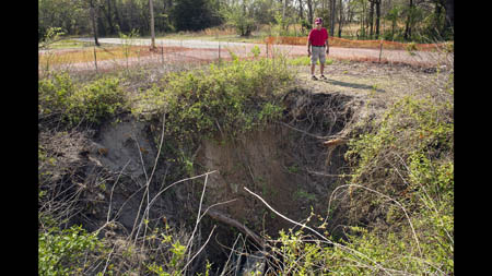 Ed Keheley, 71, stands near a collapsed mine shaft in an abandoned neighborhood in Picher. Keheley, a retired nuclear engineer who is writing a history of mining in Picher, says there are more than 100 shafts in town and 1203 shafts in the area. This one had already closed by 1926, when an illegal distillery was discovered inside it with 40,000 gallons of whiskey. Keheley says it was the largest illegal still raided during Prohibition. Born in Flippin, Ark., Keheley moved to Picher at age one, when his father came to work in the mines. The family moved to California when Ed was 14 as mining operations were declining. 'I can't think of a better place to have been raised,' he said of the close-knit community, 'there was no upper class here, so everybody was in a level playing field.' He moved back to the region after retiring and took up the cause of people affected by lead poisoning, helping to advocate for the buyout.